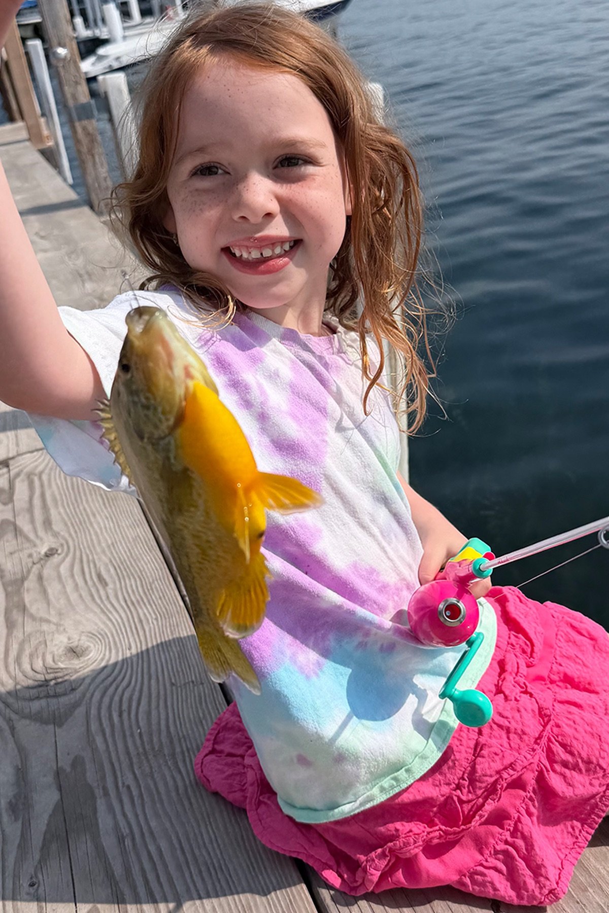 James’s daughter proudly holding a fish beside a Minnesota lake