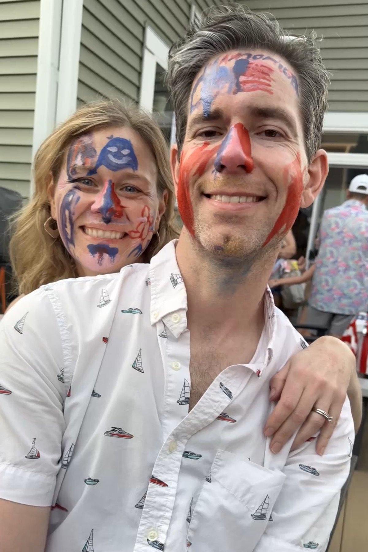 James and Emily smiling together with colorful face paint